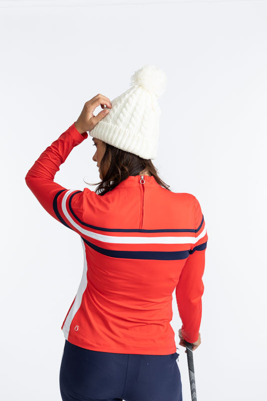 Back view of the Winter Rules Long Sleeve Golf Top in Tomato Red. This top is primarily tomato red with a 360 degree pattern of lines across the chest area. A thin, navy blue stripe followed by a spacer of tomato red, then a thicker, solid white stripe fo