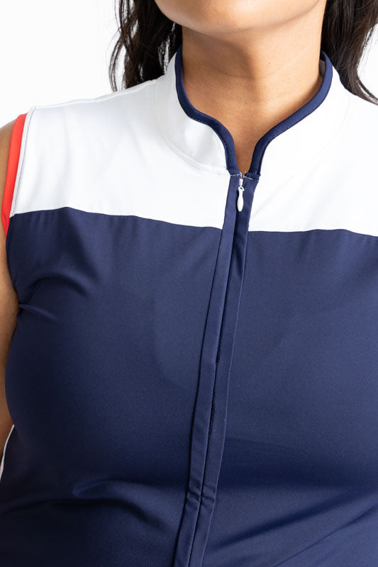 Close view of the zipper on the front of the Clubhouse Sleeveless Golf Dress in Navy Blue. You can see the white accent at the top as well as the tomato red accent around the armhole on the right side.