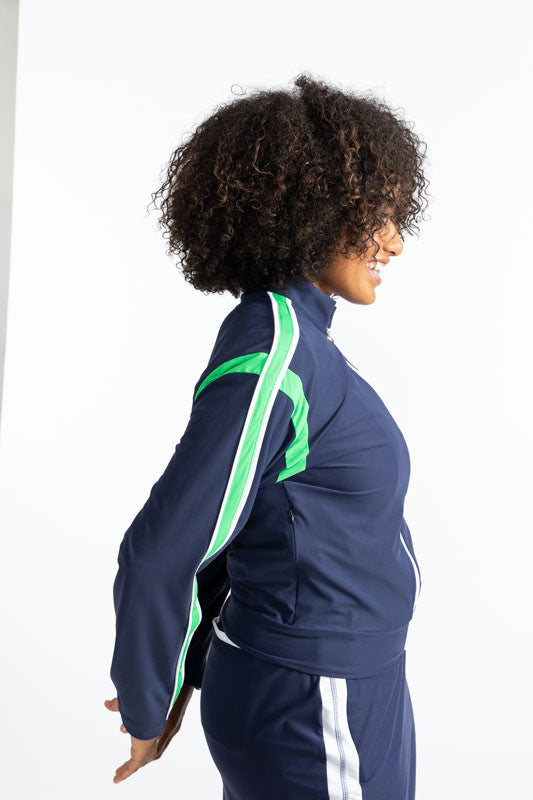 Right side view of the Warm Up Jacket in Navy Blue. This jacket is primarily navy blue with a white zipper that runs down the front of this jacket. There is also a Kelly Green stripe that runs around each armhole and a solid Kelly Green stripe with a soli