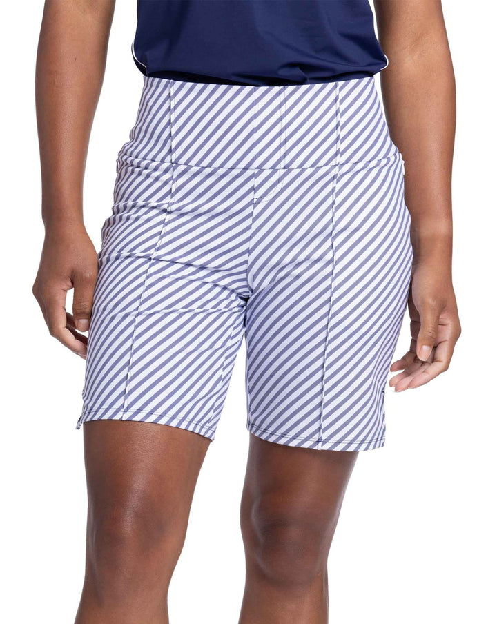 Front view of a woman wearing the Golf Glove Friendly Short in Market Stripe. The short has pink tuck seams on the front and side pockets on each side. 