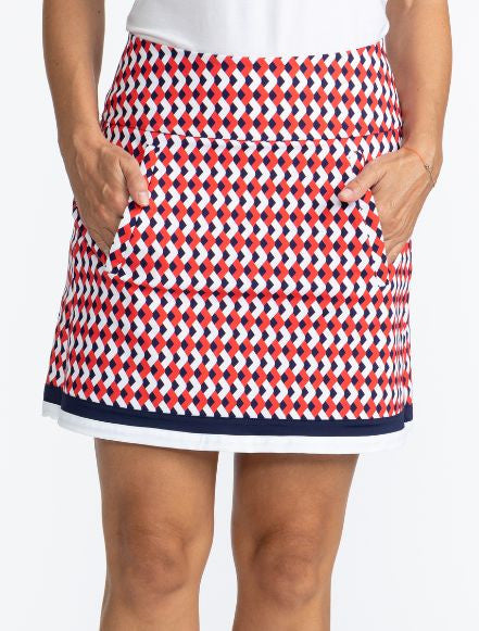 Front view of the On The Fringe Golf Skort in Chevron Tomato Red. This pattern consists of red, white, and blue chevrons with two solid stripes at the bottom of the skort - a solid navy blue stripe and a solid white stripe.