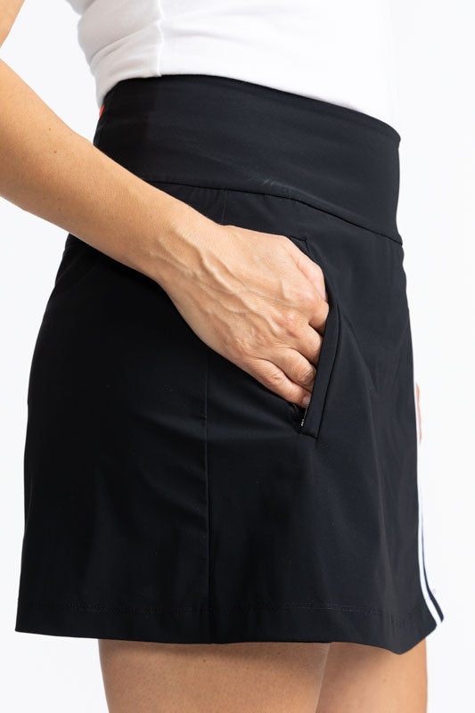 Close right side view of one of the pockets on the Skort and Short Golf Skort in Black. This is a solid black skort with two thin, white stripes that run down the front of the split on the skirt portion of the skort.