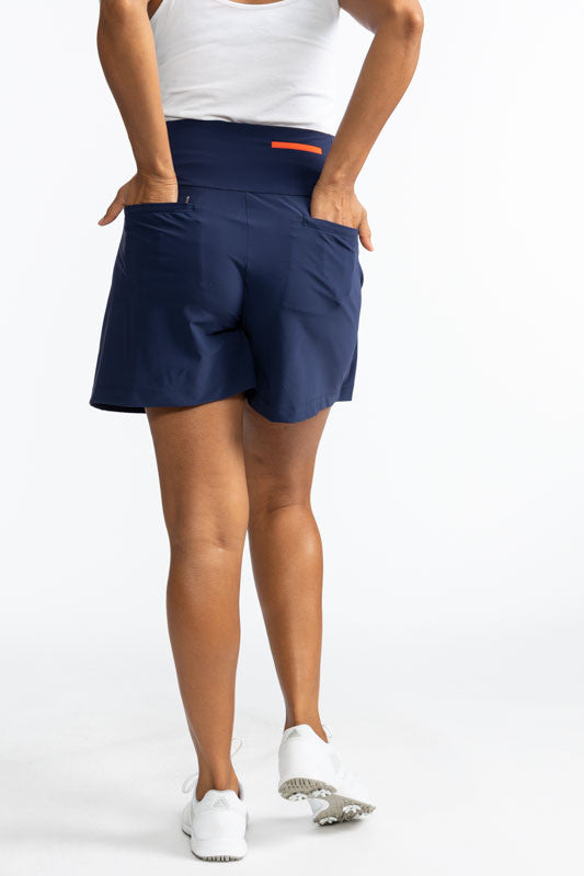 Full back view of the Skort and Short Golf Skort in Navy Blue and White. This skort is a solid navy blue with two vertical white stripes on the front along the split of this skort.
