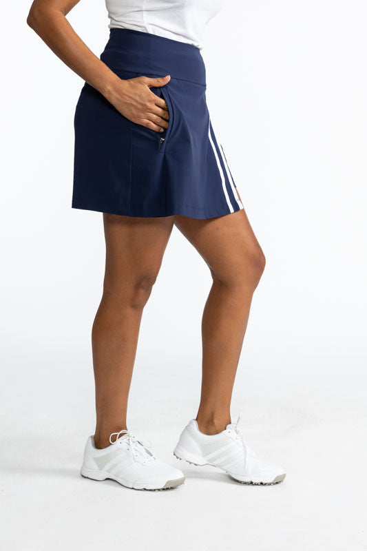 Full right side view of the Skort and Short Golf Skort in Navy Blue and White. This skort is a solid navy blue with two vertical white stripes on the front along the split of this skort.