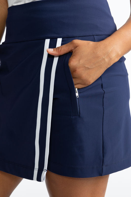 Close front and left view of the Skort and Short Golf Skort in Navy Blue and White. In this view, you can see the two vertical white stripes along the front split of this skort and one of the two side pockets.