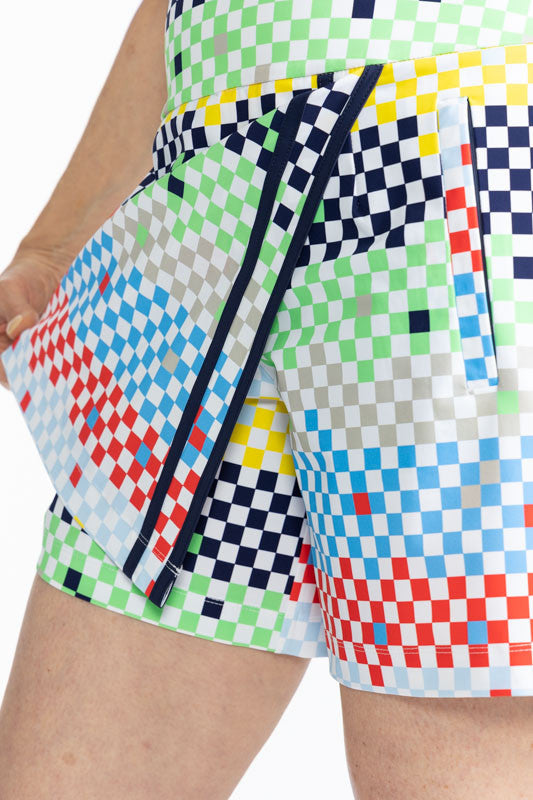Close front view showing a woman holding back the skirt portion of the skorts to show the shorts beneath the Skort and Short Golf Skort in Cheeky Check print. This print is made up of a checked horizontal patter that creates a horizontal wrap in black, gr