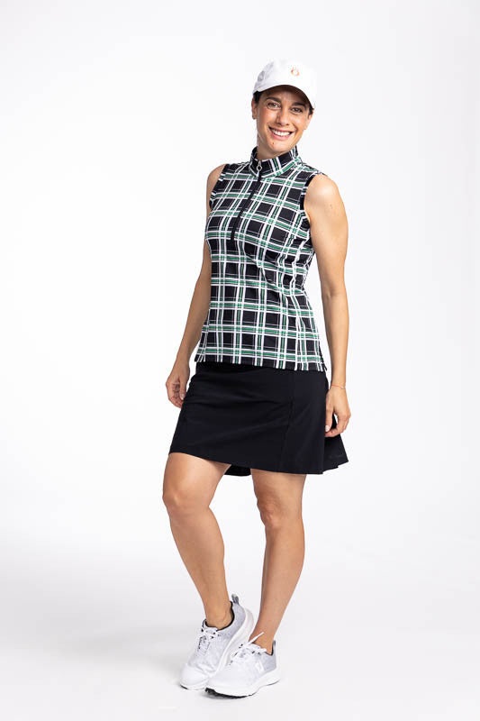 Full front and left side view of a smiling woman wearing the Cool Coulotte in black, the Keep It Covered Sleeveless Golf Top in Tartan Plaid, and the We've Got You Covered Hat in White.