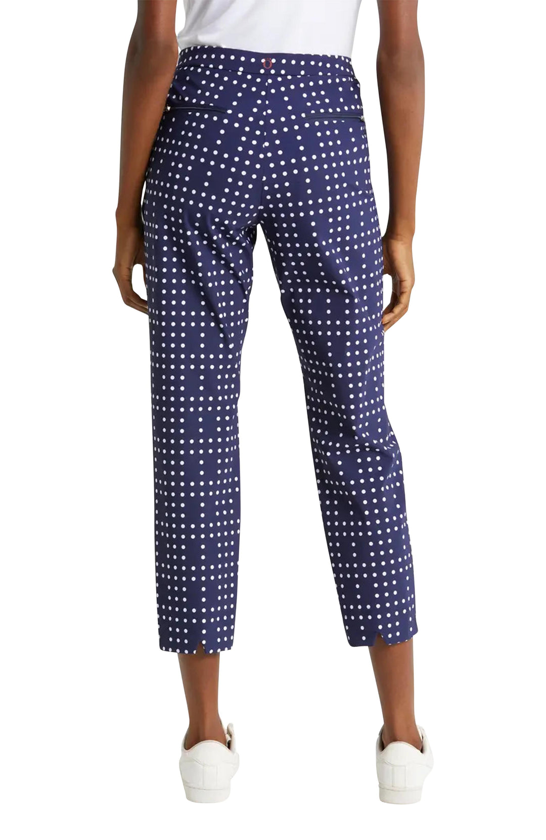 Back view of woman wearing navy polka dot crop golf pants