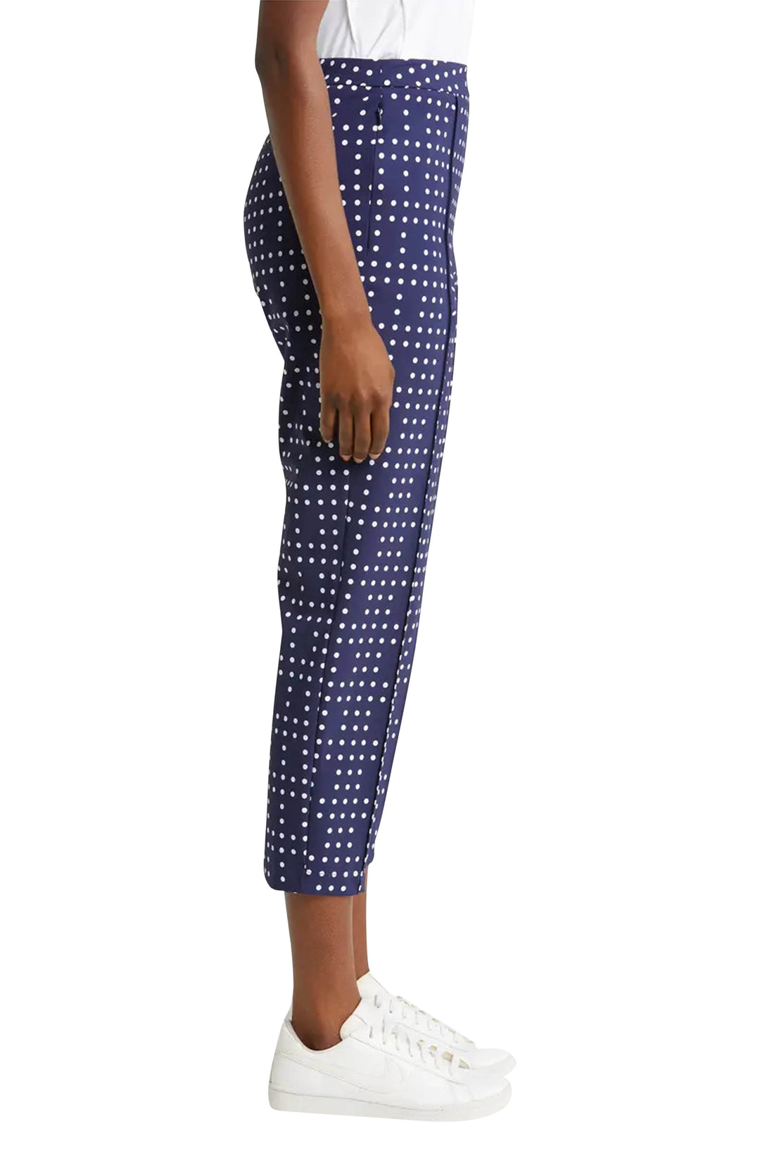 Side view woman wearing navy polka dot crop golf pants