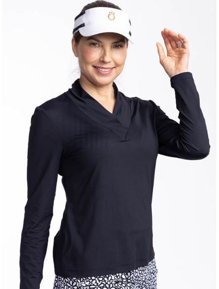 Front view of a smiling woman wearing the Lovely Layer Long Sleeve Golf Top in Black and the No Hat Hair Visor in white.