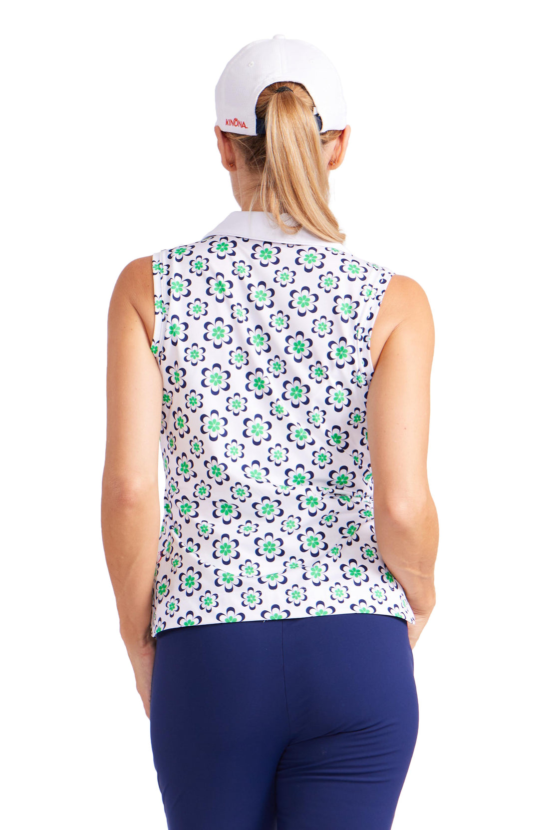 Front facing view of woman wearing sleeveless top with wallpaper floral design and white collar and v-neck trim