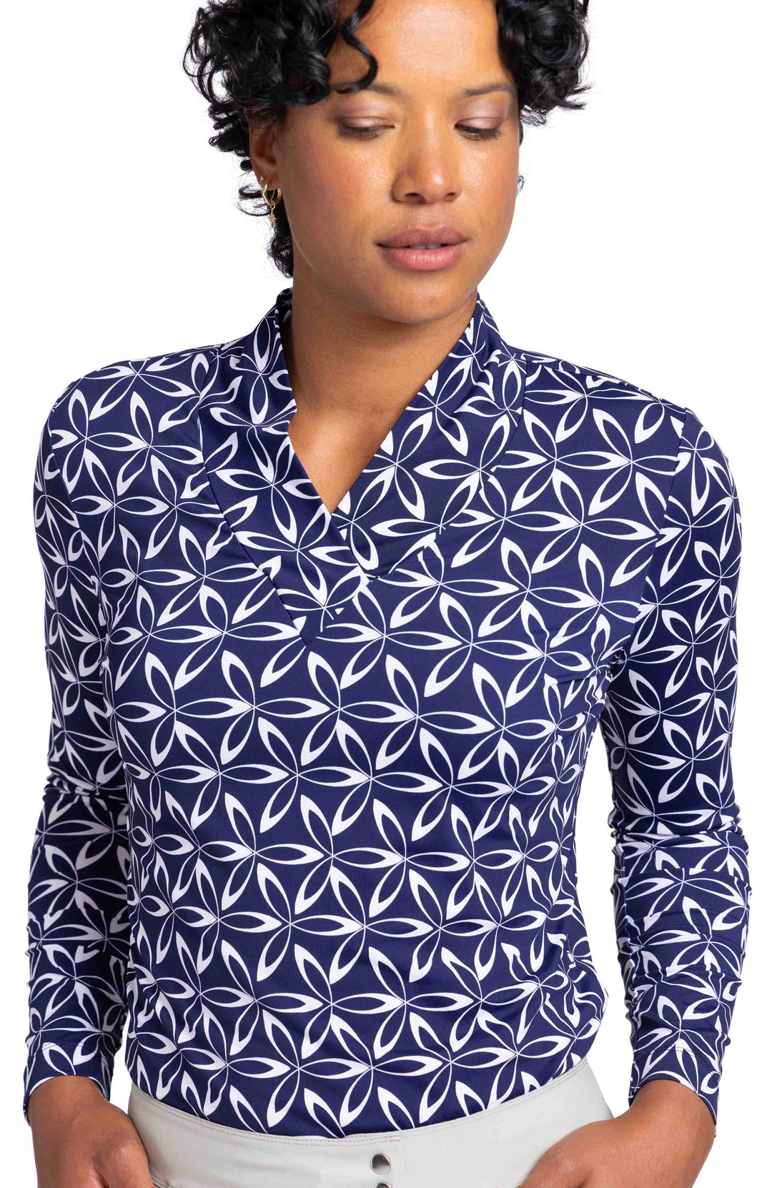 Front view of a woman wearing a v-neckline, long sleeve top in a navy and white Geo Floral print.