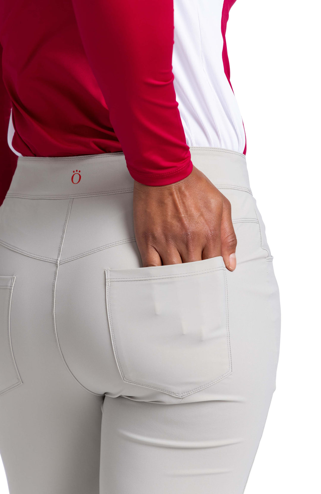 Close back view of a woman's hand in the back patch pocket of the Club Compliant pant.