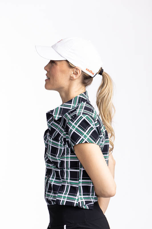 Left side view of the Tough in the Rough Short Sleeve Golf Top in Tartan Plaid and the We've Got You Covered Hat in white.