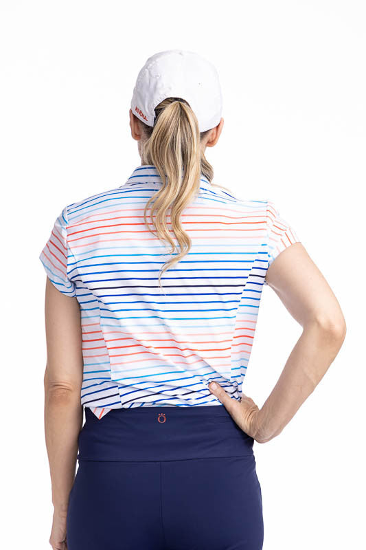 Back view of the Tough in the Rough Short Sleeve Golf Top in Sun Stripe print and the We've Got You Covered Hat in White. The Sun Stripe print consists of a mix of horizontal and vertical stripes in coral red, pacific blue, and navy blue on a white backgr