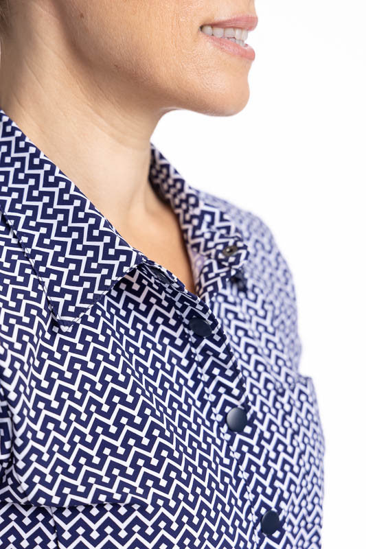 Close front view of the collar and snap front closure on the Tough in the Rough Short Sleeve Golf Top in Chic Chevron print. The Chic Chevron print consists of white chevrons on a navy blue background. The top features a snap front closure, shirt-style de