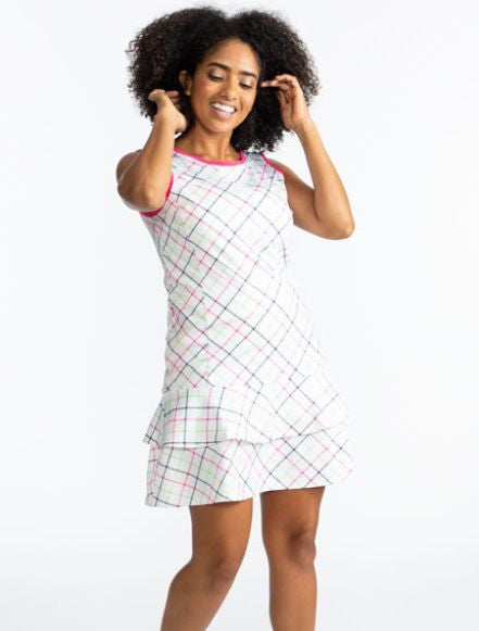 Front view of a smiling woman wearing the On In Two Sleeveless Golf Dress in Tattersall Plaid. This dress has preppy pink trim around the neckline and each armhole. The print consists of overlapping stripes of Preppy pink, Fairway green, and black on a wh