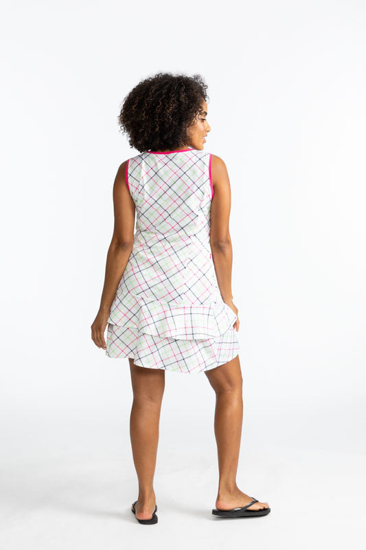 Full back view of a woman wearing the On In Two Sleeveless Golf Dress in Tattersall Plaid. This dress has preppy pink trim around the neckline and each armhole. The print consists of overlapping stripes of Preppy pink, Fairway green, and black on a white 