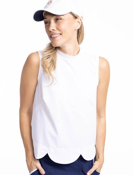 Close front view of the On The Edge Sleeveless Golf Top in White and the We've Got You Covered Hat in White. This top features a back zipper and a feminine scallop design along the hemline.