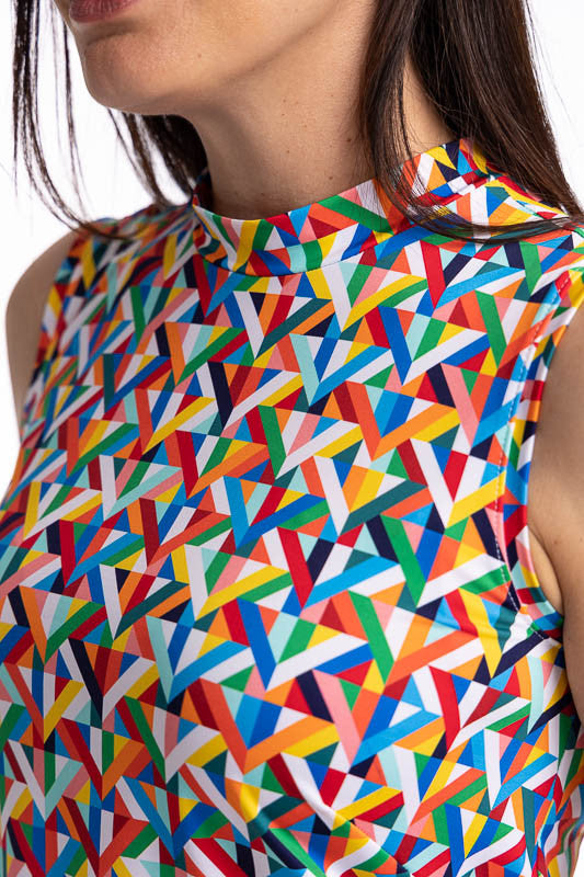 Close front view of the mock neckline on the On The Edge Sleeveless Golf Top in K All Day Print. The K All Day print is an abstract confetti-style mirrored K-shaped pattern in red, orange, yellow, green, blue, black and white. This top features a low mock