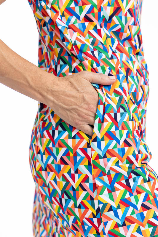 Close right side view of the side pocket on the On The Edge Sleeveless Golf Dress in K All Day print. The K All Day print is an abstract confetti-style mirrored K-shaped pattern in red, orange, yellow, green, blue, black and white.