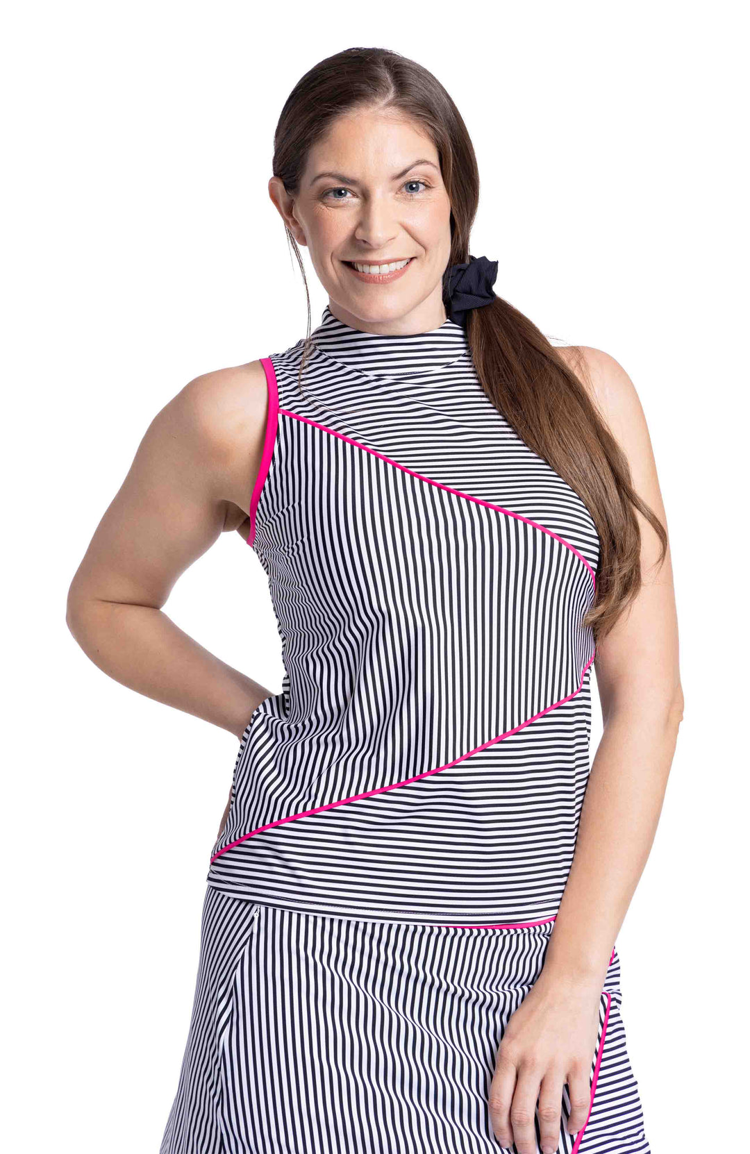 Woman wearing black and white angled striped sleeveless top and skort with pink trim