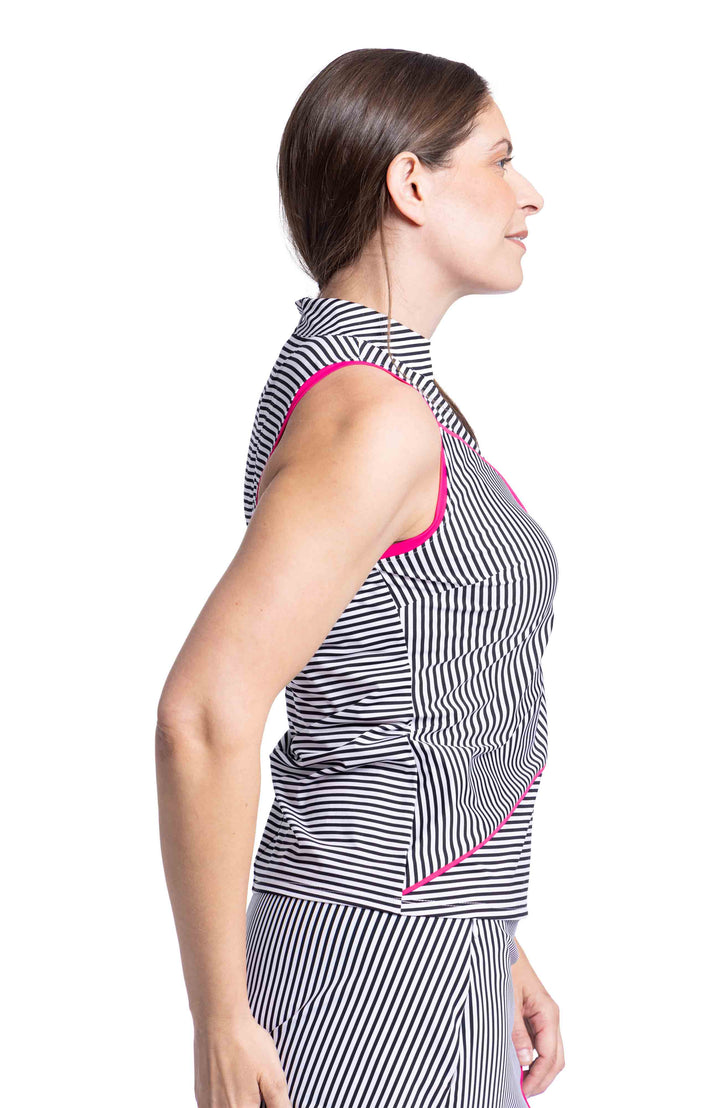 Side view of woman wearing black and white angled striped sleeveless top and skort with pink trim