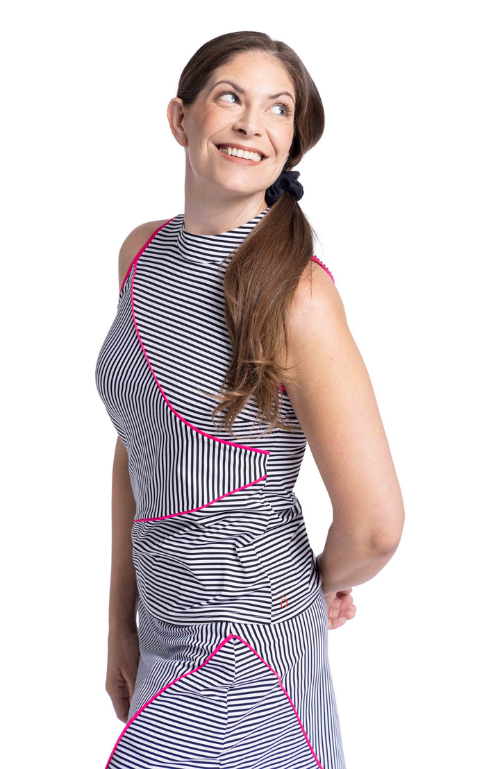 Woman wearing black and white angled striped sleeveless top and skort with pink trim