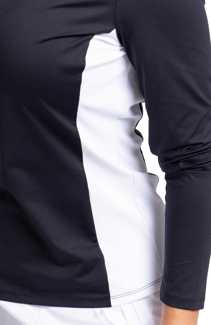 Up close image of a woman wearing a black longsleeve top with contrasting white side panel.