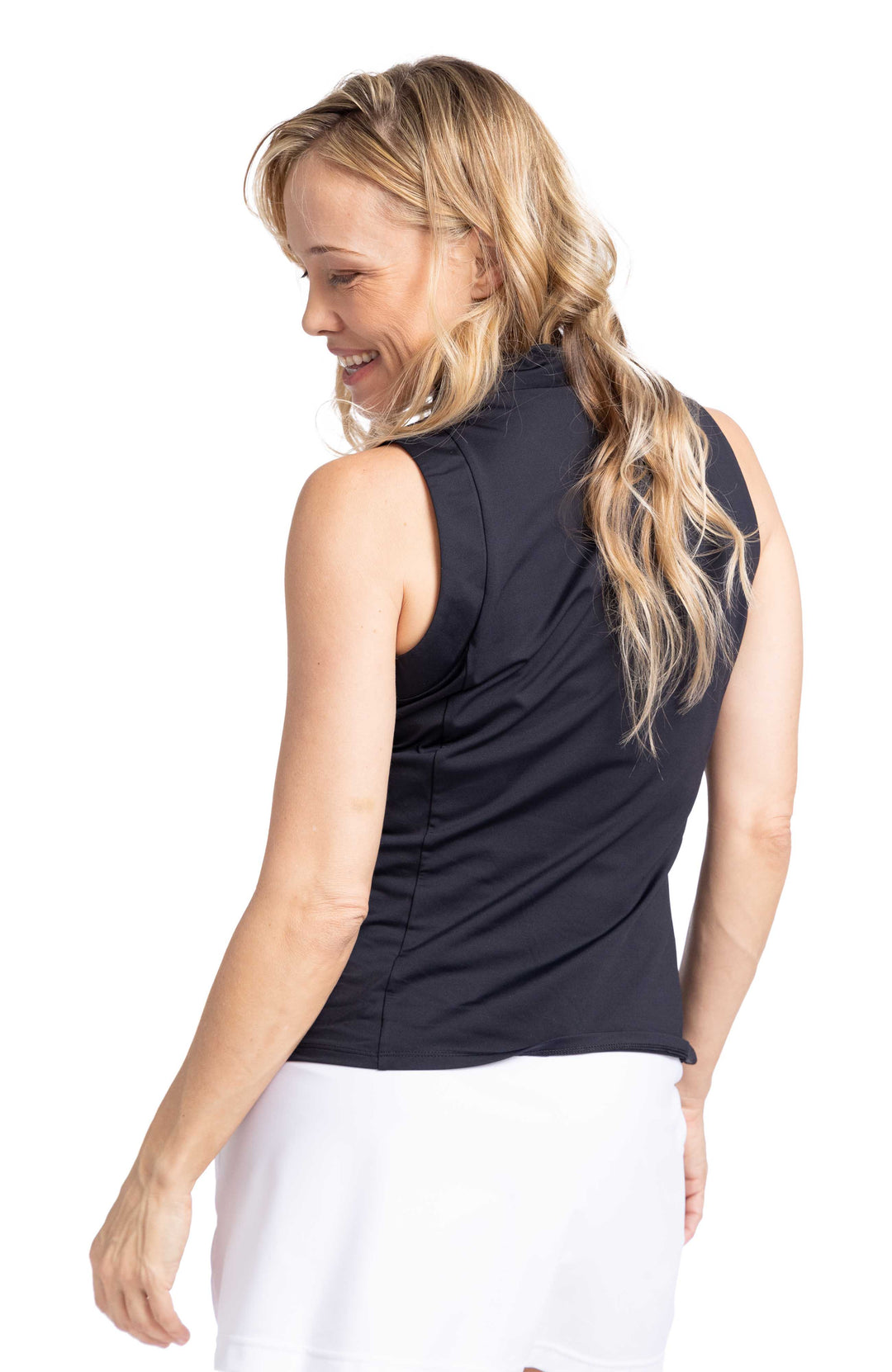 Back view of woman wearing in black sleeveless vneck golf top and white golf skort