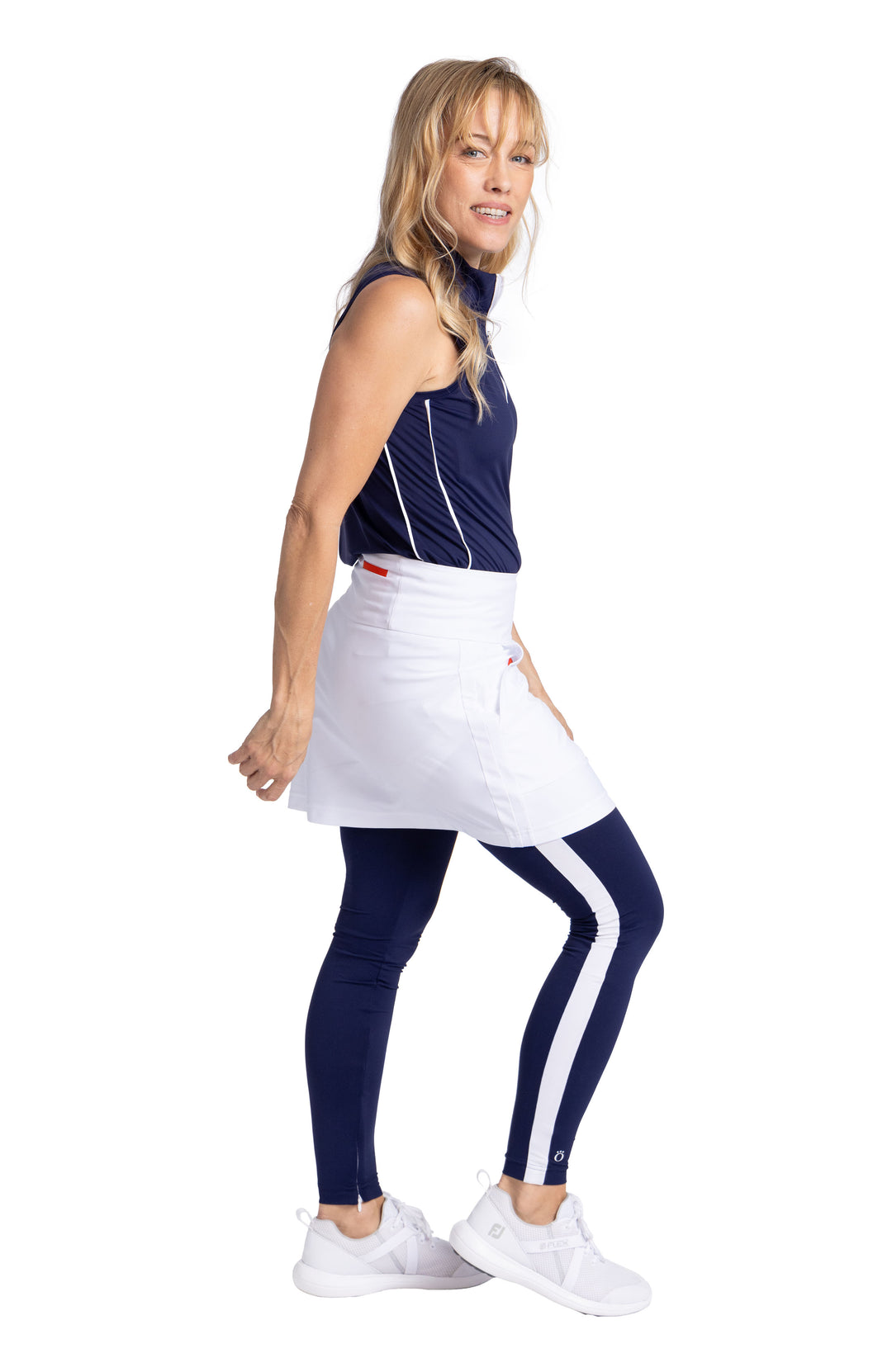 Side view of a woman wearing the Sun's Out Thigh Highs in navy blue, the Keep It Covered Sleeveless top in navy blue, and a white Pocket Envy Skort.