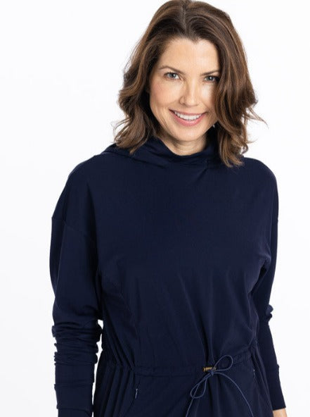 Front view of a smiling woman wearing an Apres 18 Anorak Longsleeve Hoodie in navy blue