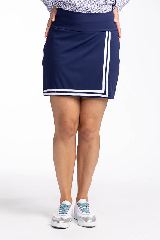 Front view of the No Break Golf Skort in Navy Blue. This is a navy blue skort with two white stripes that run in an "L" shape from the top left side down to the hemline and to the right. It features a faux wrap front with a layer beneath and built-in, bre