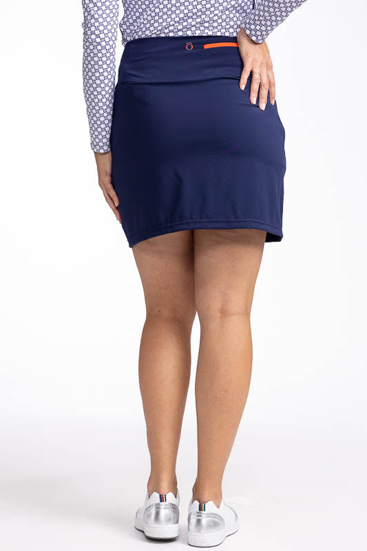 Back view of the No Break Golf Skort in Navy Blue. This is a navy blue skort with two white stripes that run in an "L" shape from the top left side down to the hemline and to the right. It features a faux wrap front with a layer beneath and built-in, brea