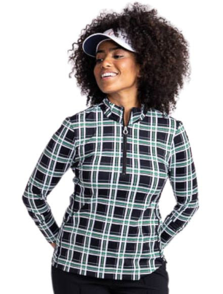 Front view of a smiling woman wearing the Keep It Covered Long Sleeve Golf Top in Tartan Plaid and the No Hat Hair Visor in white.