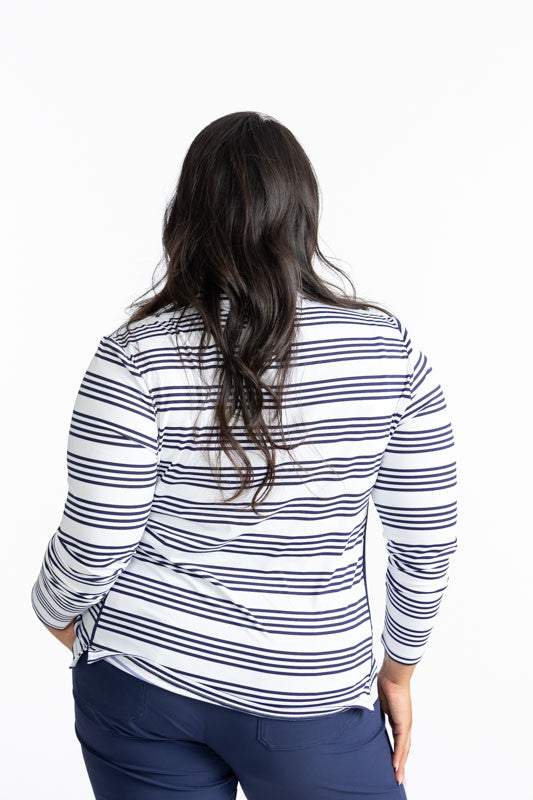 Back view of the Keep It Covered Long Sleeve Golf Top in Shutter Stripe. This pattern is a grouping of four horizontal, navy blue stripes with white space in between from top to bottom on this top.