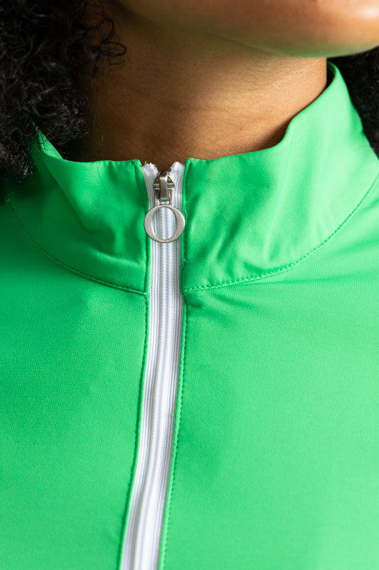 Close front view of the zipper and neckline on the Keep It Covered Long Sleeve Golf Top in Kelly Green. In this view you can see the white quarter zip zipper on the front of this top.