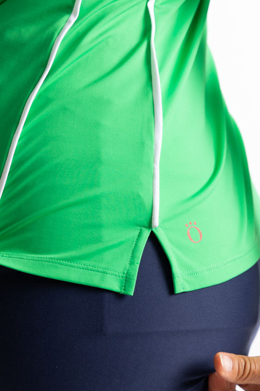 Close left side view of the hemline on the Keep It Covered Long Sleeve Golf Top in Kelly Green. In this view, you can see the two thin, solid white stripes that run down the side on this top.