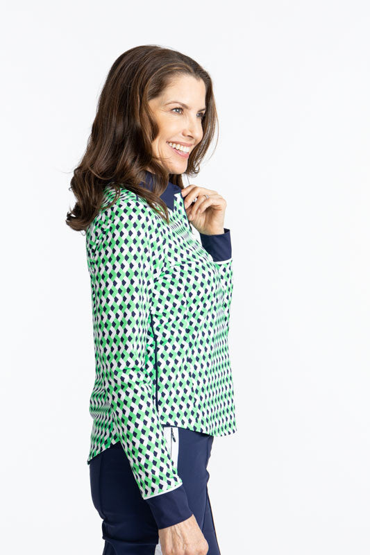 Right side view of the At The Pin Long Sleeve Golf Top in Chevron Kelly Green. The collar on this top is solid navy blue as well as the cuffs on each arm of this top.
