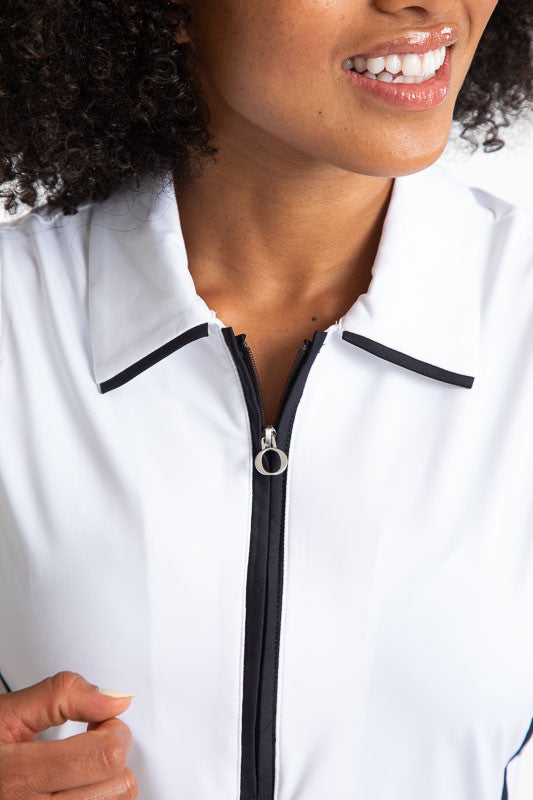 Close front view of the collar and zipper on the Swing Away Sleeveless Golf Top in White. This top has black accents down the front zipper,  around each sleeve, and two stripes on each side. 
