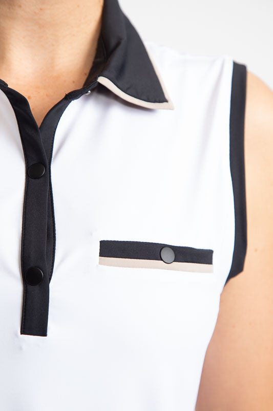 Close front left view of the Sun Seeker Sleeveless Golf Top in White.  In this picture, you can see the black collar and black accents down the front snaps, the black accent around the left sleeve, and the faux pocket on the front. 