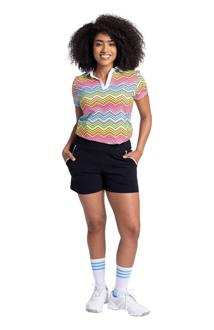 Woman wearing summer herringbone golf polo and women's black shorts