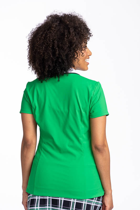 Back view of the Classic and Fantastic Short Sleeve Golf Top in Rye Grass Green. This is a solid green top with a contrasting white V-neck and a white collar with black trim on the collar's edge.