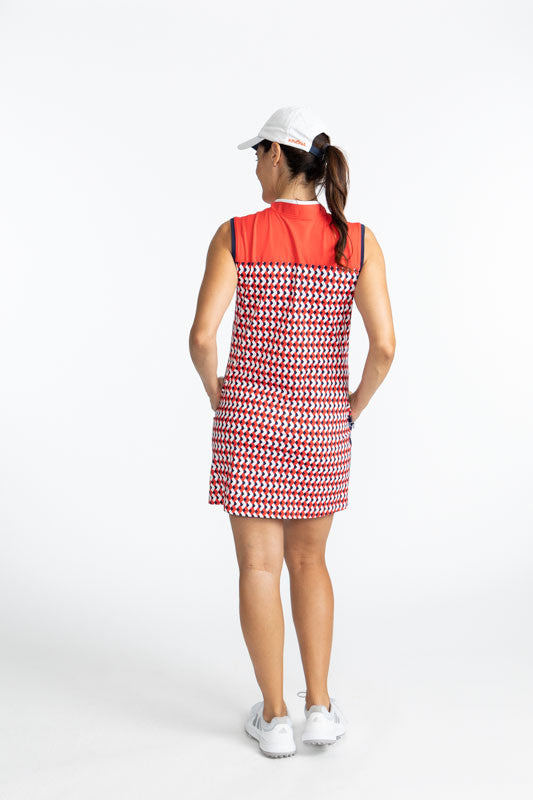 Back view of the Clubhouse Sleeveless Golf Dress in Chevron Tomato Red. This dress has a solid tomato red accent at the top, white accents around the top of the dress and on either size of the white zipper that runs down the front of this dress, a wide, n