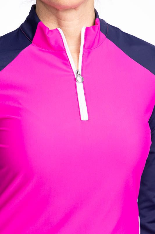 Close front view of the quarter zip front with reinforced "O" zipper pull on the Cap to Tap Long Sleeve Golf Top in Open Air Pink. This top is a solid pink top with navy blue sleeves and neckline and white stretch rib sides.