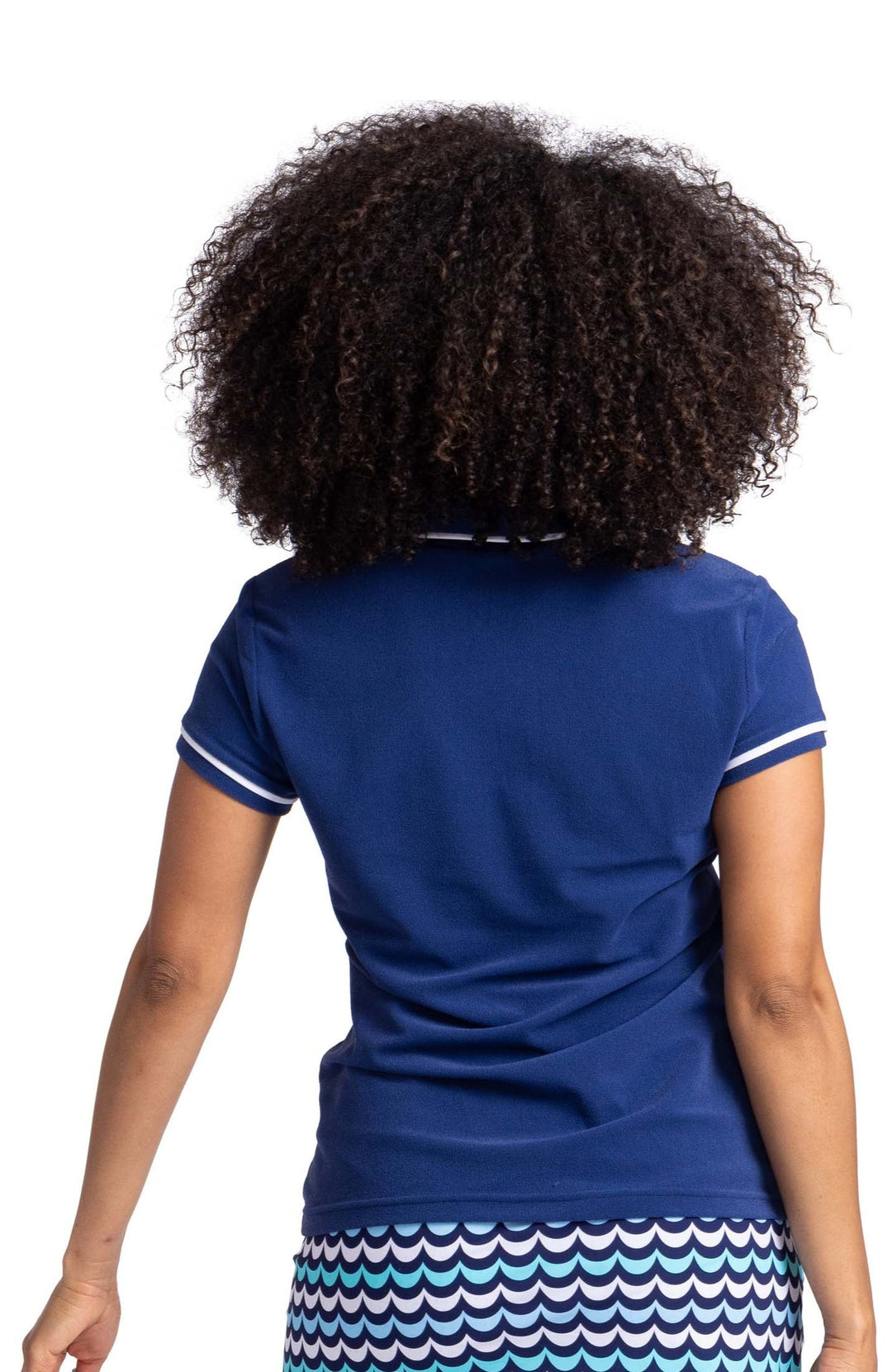 Back view of a woman wearing a short sleeve, navy blue top with white trim around the sleeves and collar.