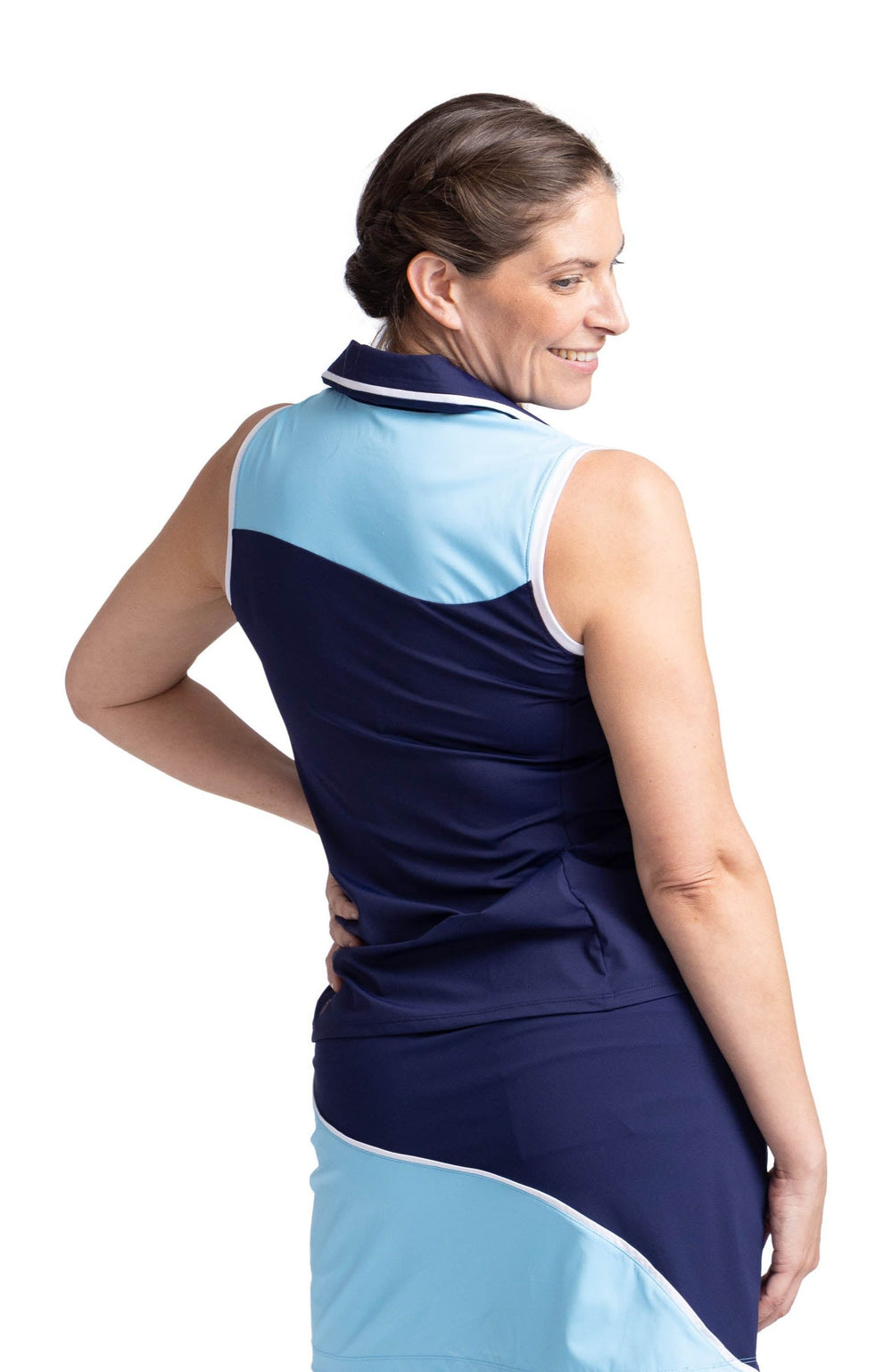 Back view of a woman wearing a sleeveless top with a light blue panel above the yoke and navy blue below the yoke. The top has white trim around the collar and armholes. 