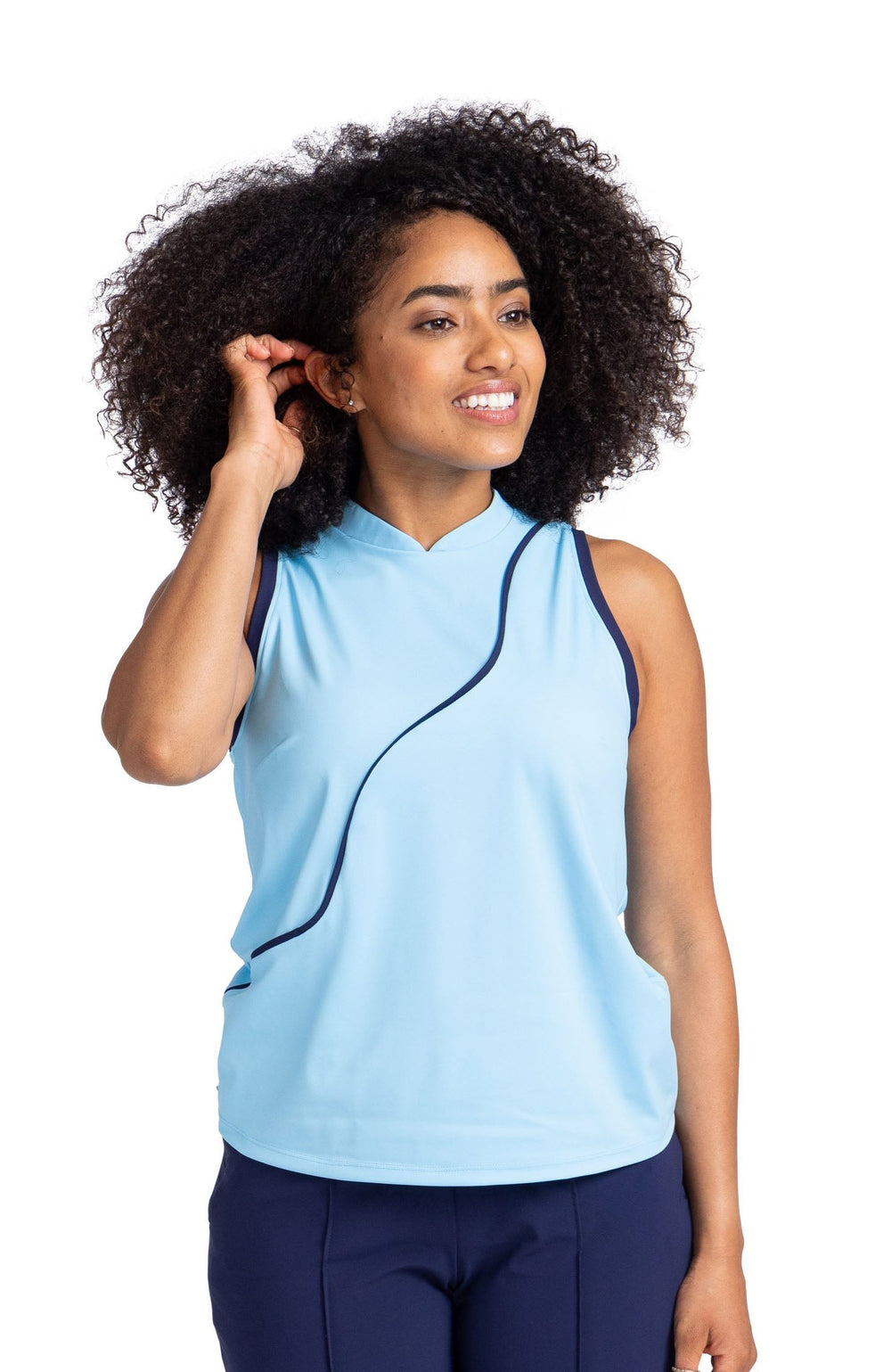 Full front view of a woman wearing a light blue sleeveless top with navy blue contrasting trim on the armholes and a navy blue wavy seam down the front. The top is paired with the navy blue Tailored Crop Golf Pant. 