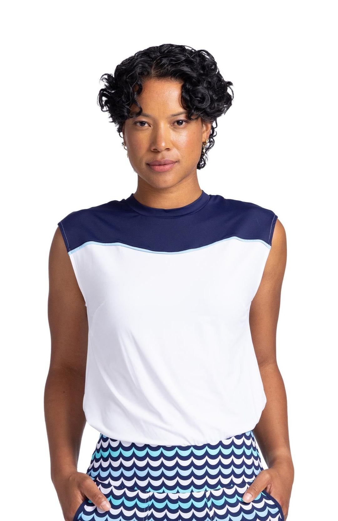 Front view of a woman wearing a cap sleeved top with a navy blue panel above the wavy yoke seam and white below the yoke. 