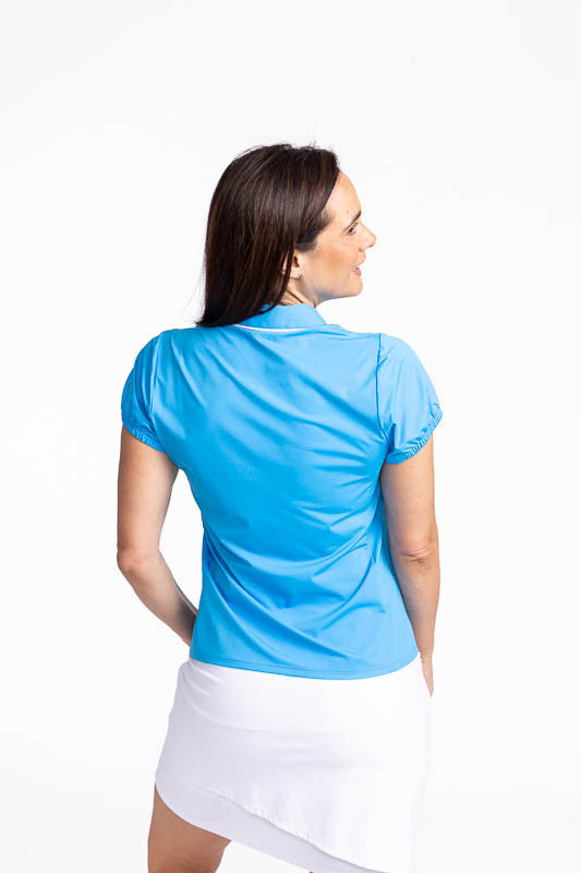 Back view of the Prettier Than A Polo Short Sleeve Golf Top in Pacific Blue. This is a solid blue top with white piping on the collar and a white front quarter zip.
